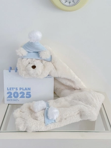 Detail of plush bear scarf with blue nightcap and soft pom-pom in winter setting