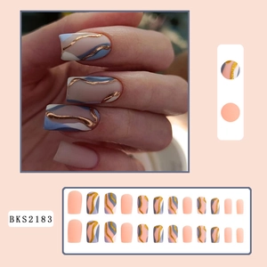 Detail view of square nude pink and blue press-on nails with gold glitter wavy lines
