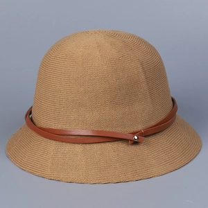 Detailed close-up of khaki knit bucket hat featuring a brown leather strap and metal rivet