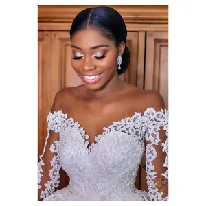 Close-up of white lace bridal gown featuring intricate floral patterns and pearl beading
