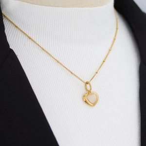 Elegant gold heart necklace with white mother of pearl pendant on a beaded chain