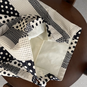 Dettaglio della borsa in tela a pois bianchi e neri con cuciture e fodera in cotone