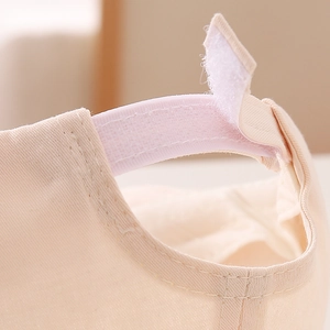 Detail of adjustable Velcro strap on the back of beige baby baseball cap for a secure fit
