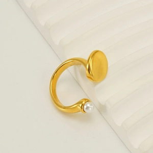 Detail of adjustable gold ring with a single pearl on a modern plaster pedestal