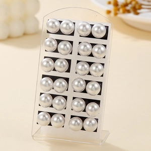 Set of 12 pairs of minimalist white round faux pearl stud earrings on display stand