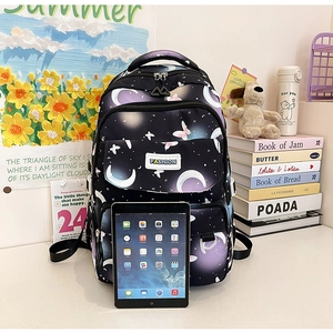 Close-up of a black star and moon pattern backpack with a tablet for size reference