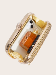 Detail view of gold glitter clutch interior showing capacity for phone and lipstick