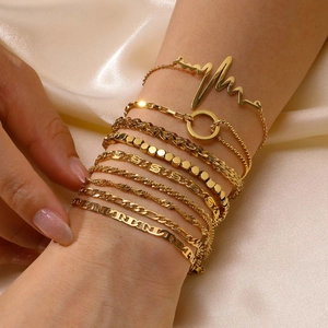 Close-up of 9-piece gold-plated bracelet set with heart wave and various chain textures