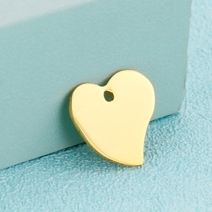 Gros plan d'un pendentif en forme de cœur en métal doré poli pour bijoux artisanaux