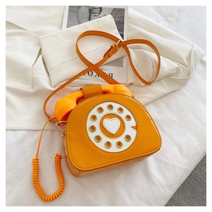 Detail of creative vintage telephone crossbody bag with dial plate and heart accent