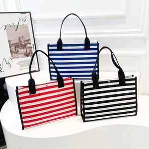 Three minimalist canvas tote bags with blue, red, and black stripes and black handles