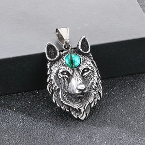 Detail of vintage wolf head pendant with green opal stone inlay on a black box