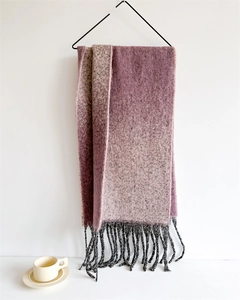 Detail of pink-purple gradient scarf with fringe texture hung by a beige cup