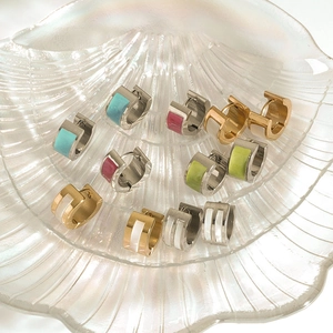 Detailed macro shot of 18K gold and silver steel hoop earrings with shell inlay