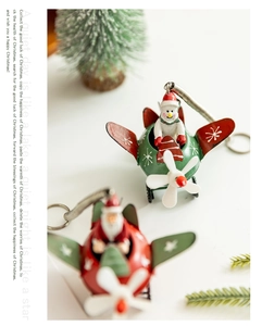 Detail of metal Santa and Snowman airplane pendants on a minimalist festive desk