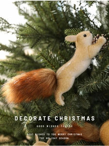 Detailed view of furry squirrel ornament holding a pinecone on a Christmas tree branch