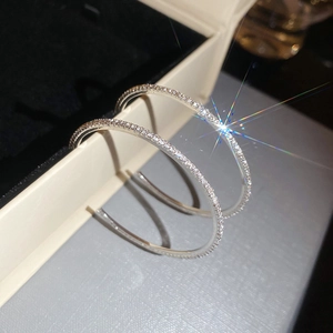 Macro close-up of sparkling silver hoop earrings encrusted with small zirconia stones