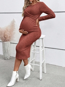 Detail of rust red maternity knit dress featuring a cross-wrap front and ribbed texture