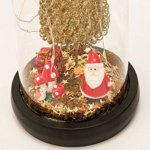 Detail view of a Christmas glass globe with Santa, tree, LED lights and black base