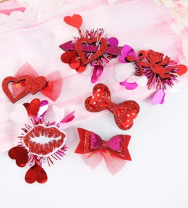 Detail shot of Valentine's Day hair clips featuring red glitter hearts and tulle bows