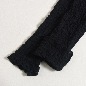 Macro shot of 3D textured bubble fabric on a black dress highlighting material detail