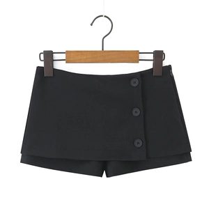 Dettaglio gonna-pantalone nera a trapezio con tre bottoni decorativi e spacco