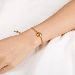 Detailed shot of gold Aries zodiac bracelet with zircon inlay on box chain and bolo clasp