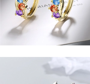 Detail of gold huggie earrings with colorful blue, orange, and purple round-cut crystals