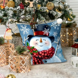 Detailed close-up of a festive Christmas pillow with snowman print near a holiday tree