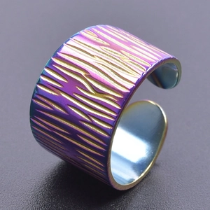 Detailed macro view of rainbow gradient tree bark texture on wide stainless steel ring
