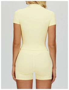 Vista posteriore del set yoga color crema con top a maniche corte e pantaloncini elasticizzati