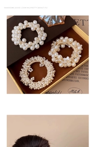 Detail of cream pearl hair ties with floral charms and crystals in elegant gift box