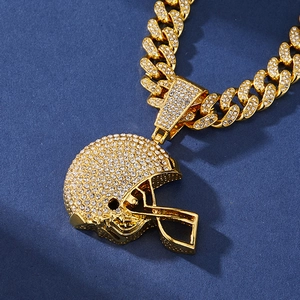 Close-up of gold-plated iced-out American football helmet pendant on heavy link chain