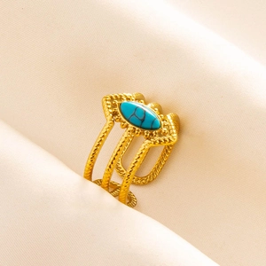 Macro shot of gold stainless steel triple twisted ring featuring an oval turquoise stone