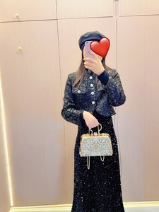 Elegant gold evening bag with geometric bead embroidery paired with a black sequin dress