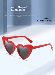 Detailed close-up of heart-shaped sunglasses with red frame and dark gray lenses