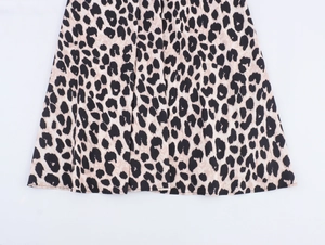 Detailed view of the leopard print fabric texture and flowing hem of the vintage dress