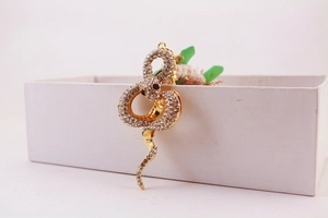 Detailed close-up of a golden snake keychain with sparkling crystal rhinestones