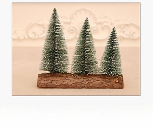 Three mini snow-flocked Christmas trees with natural wood base for festive table decor