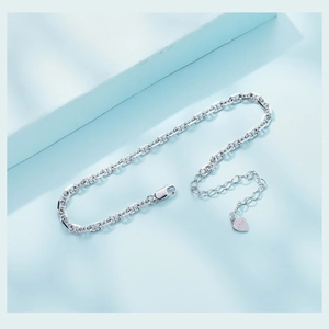 Macro shot of S925 sterling silver anchor chain bracelet with lobster clasp and heart charm