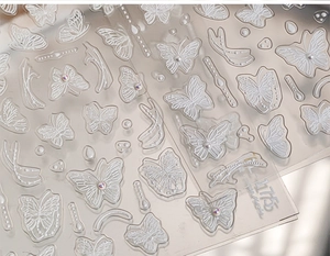 Vue macro détaillée de stickers ongles papillon 3D gaufrés avec petits accents de perles