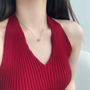 Close-up of a s925 silver necklace with a heart-shaped pink zircon pendant on a model