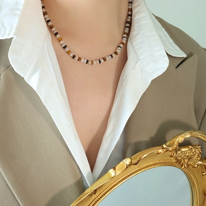 Minimalist beaded necklace with natural zebra jade and tiger eye stones on female model