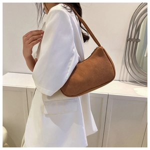 Brown corduroy baguette shoulder bag shown as a stylish crescent underarm bag on model