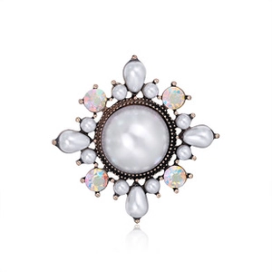 Detailed macro view of a vintage flower brooch featuring a large center pearl and rhinestones