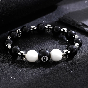 Obsidian bead bracelet with silver crosses and black 8 pool ball on dark textured stone