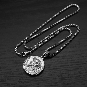 Detail of silver round medallion pendant with relief engraving on a square box chain