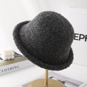 Detailed texture of thick dark grey wool cloche hat on a premium display stand