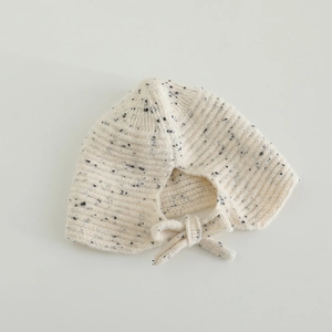Détail de la maille et des liens de l'attache du bonnet d'hiver enfant en laine beige chinée