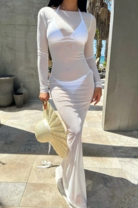 Détail d'une robe de plage longue en tulle blanc transparent à manches longues et chapeau